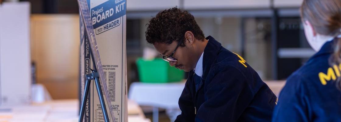Student setting up poster at Agriscience Fair
