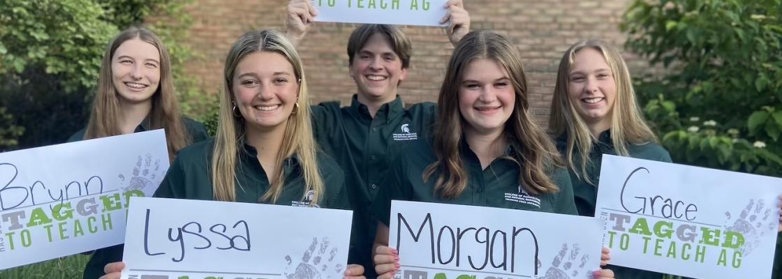 Students posing with "tagged to teach ag" signs