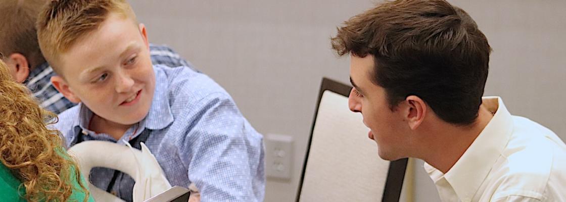 Student and facilitator chatting at conference