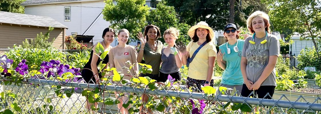 a group of students standing in front of a rain garden