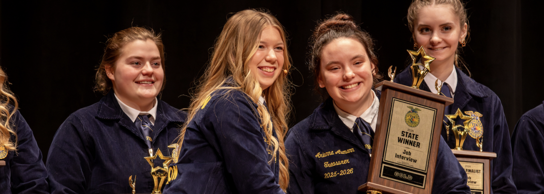 Student receiving state winning trophy on stage