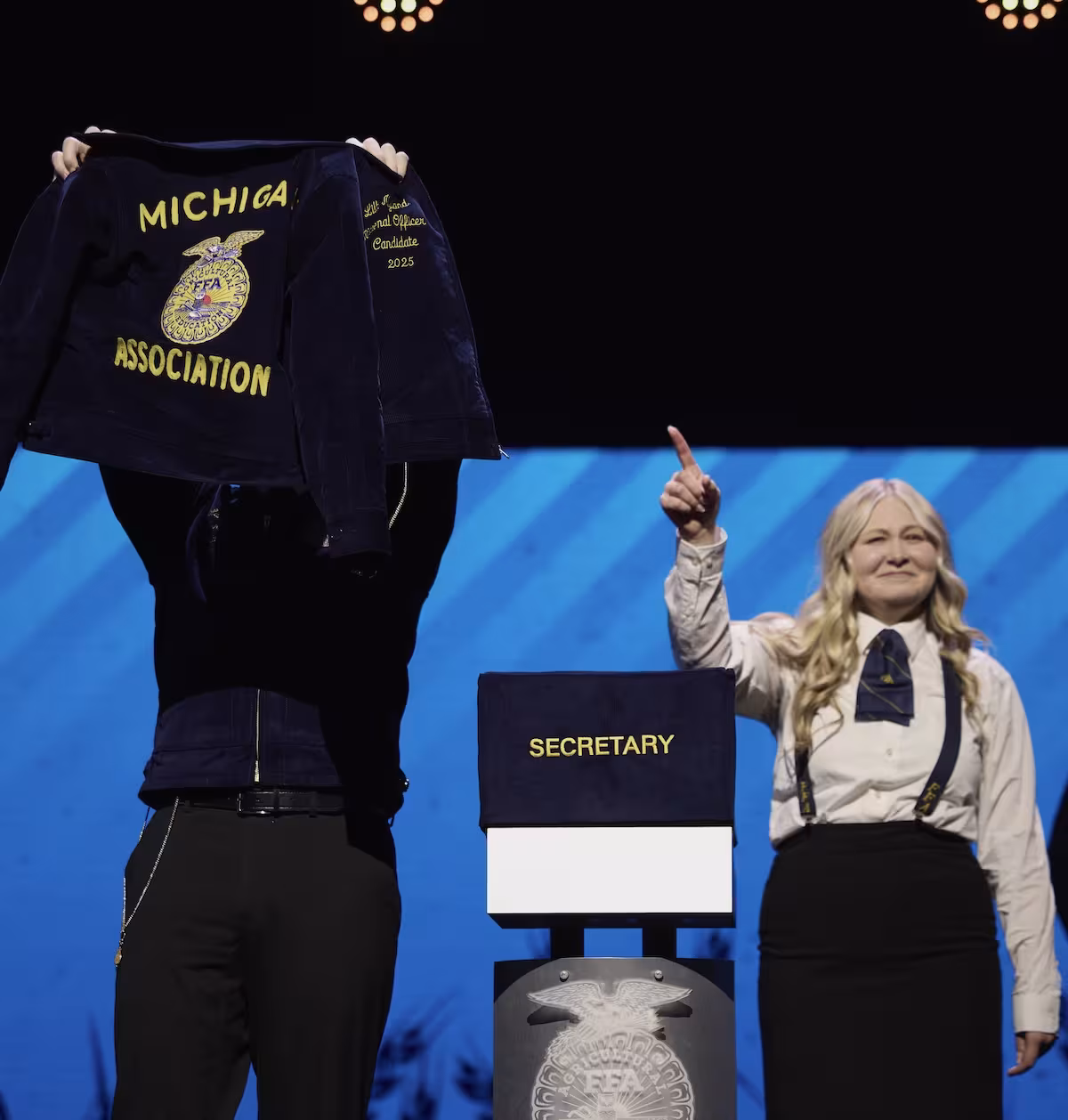 National officer getting new jacket on stage